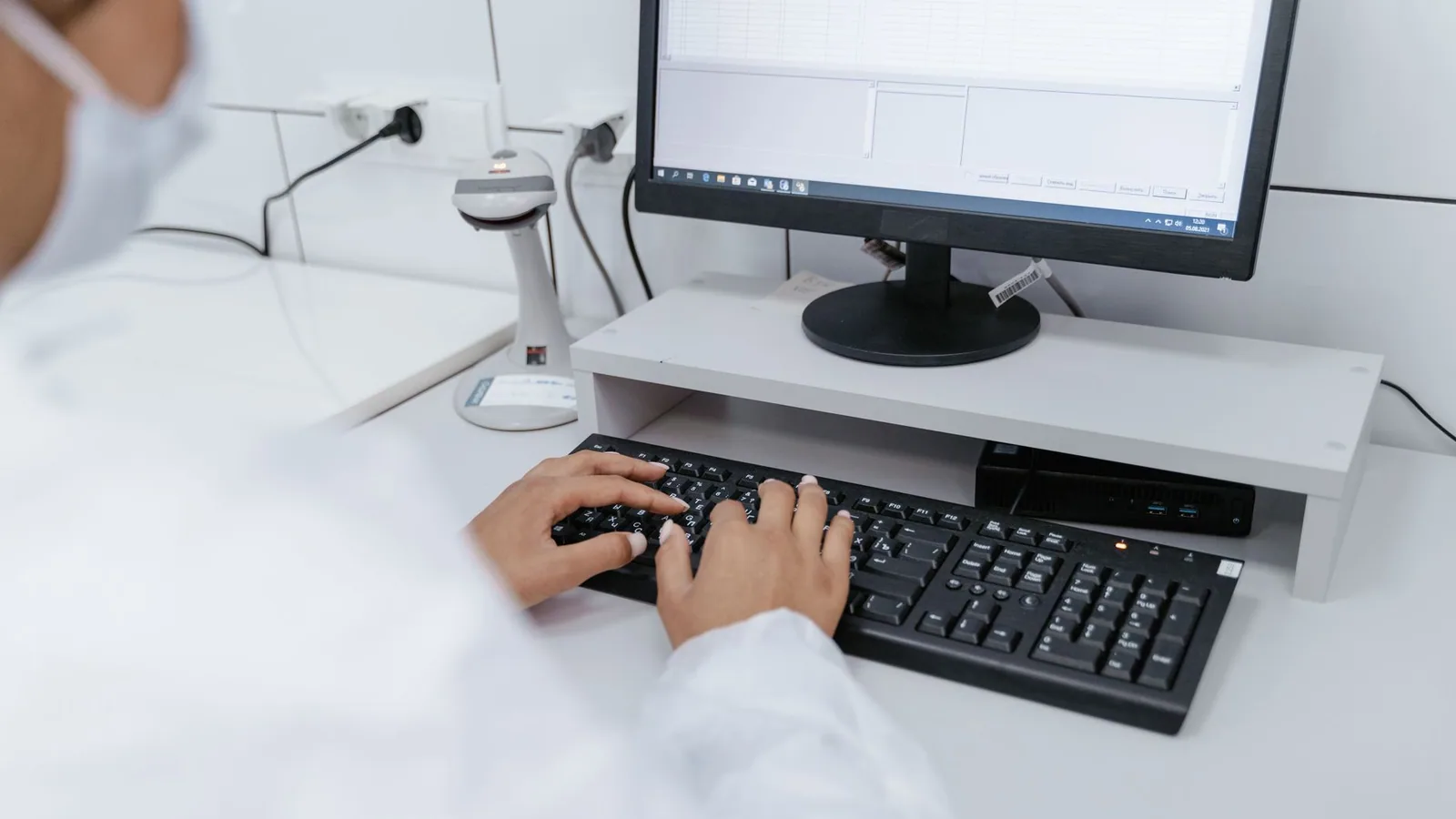 Scientist in white coat using a computer in a laboratory setting, focusing on data analysis