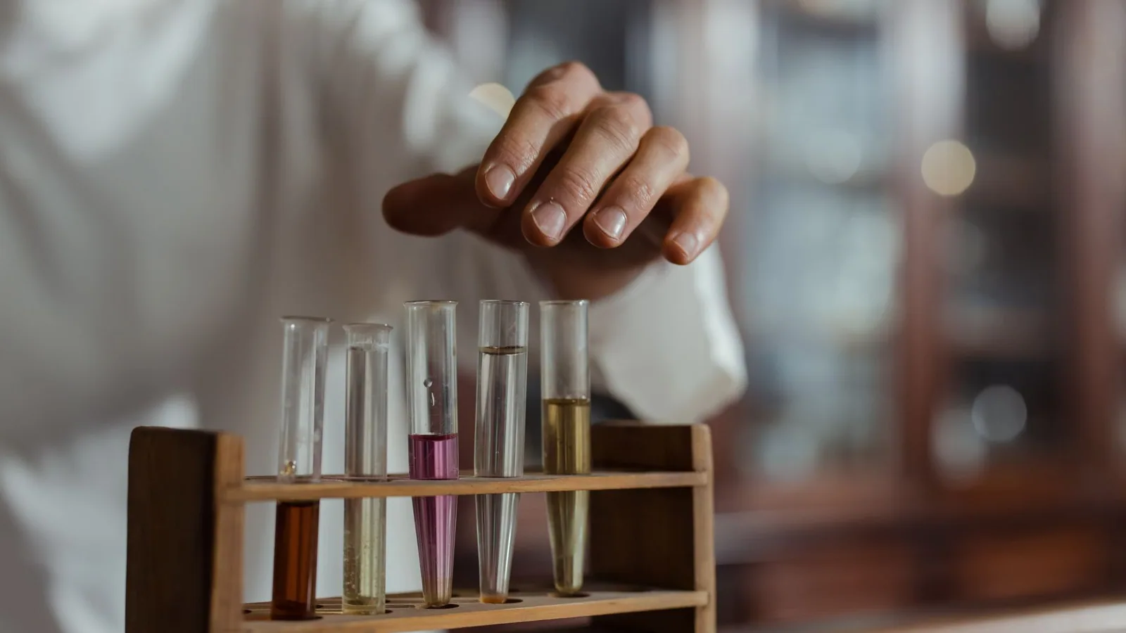 Close-up of a hand handling test tubes in a laboratory showcasing scientific research