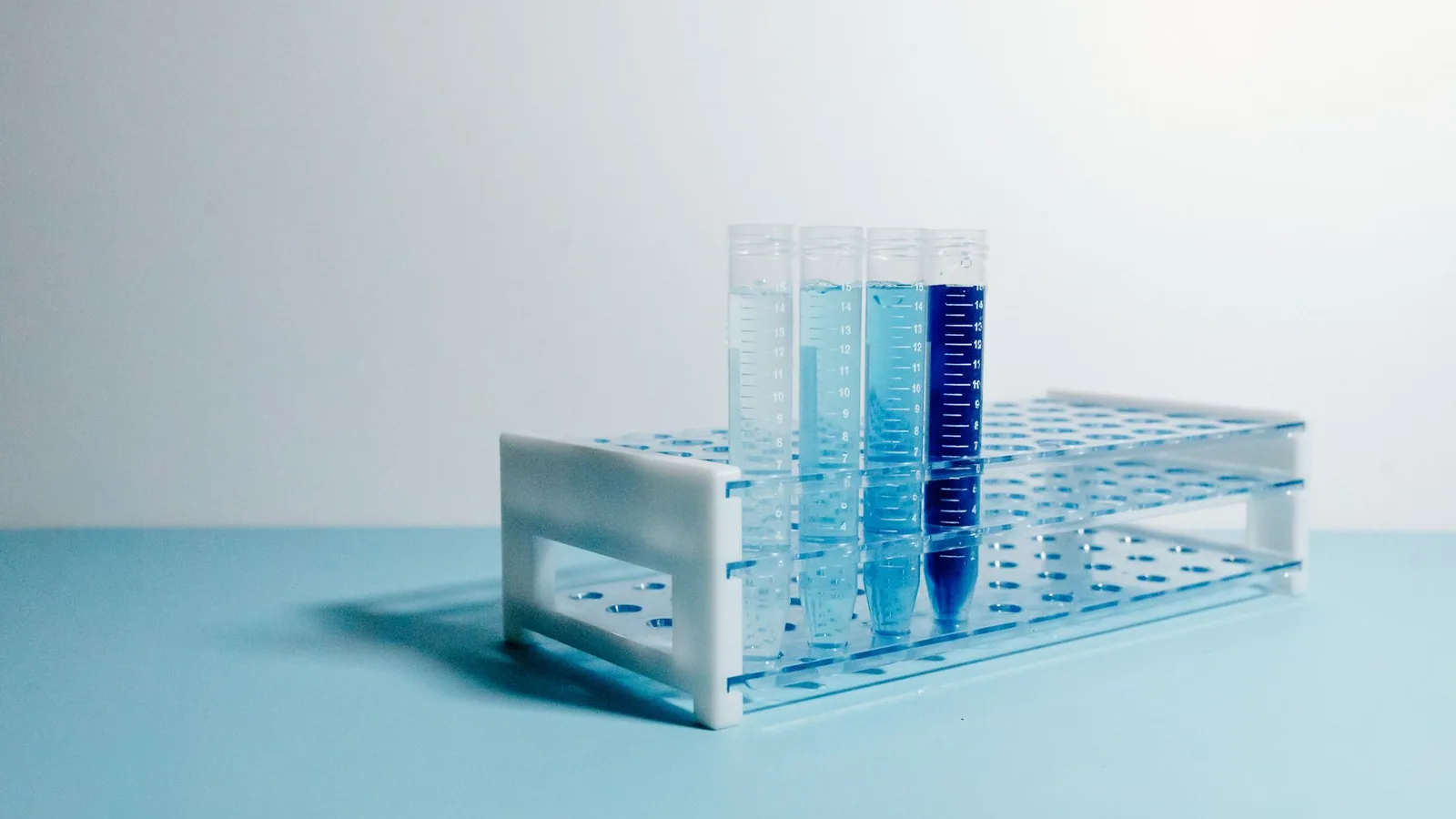 A minimalist arrangement of test tubes on a blue surface, perfect for science and laboratory themes