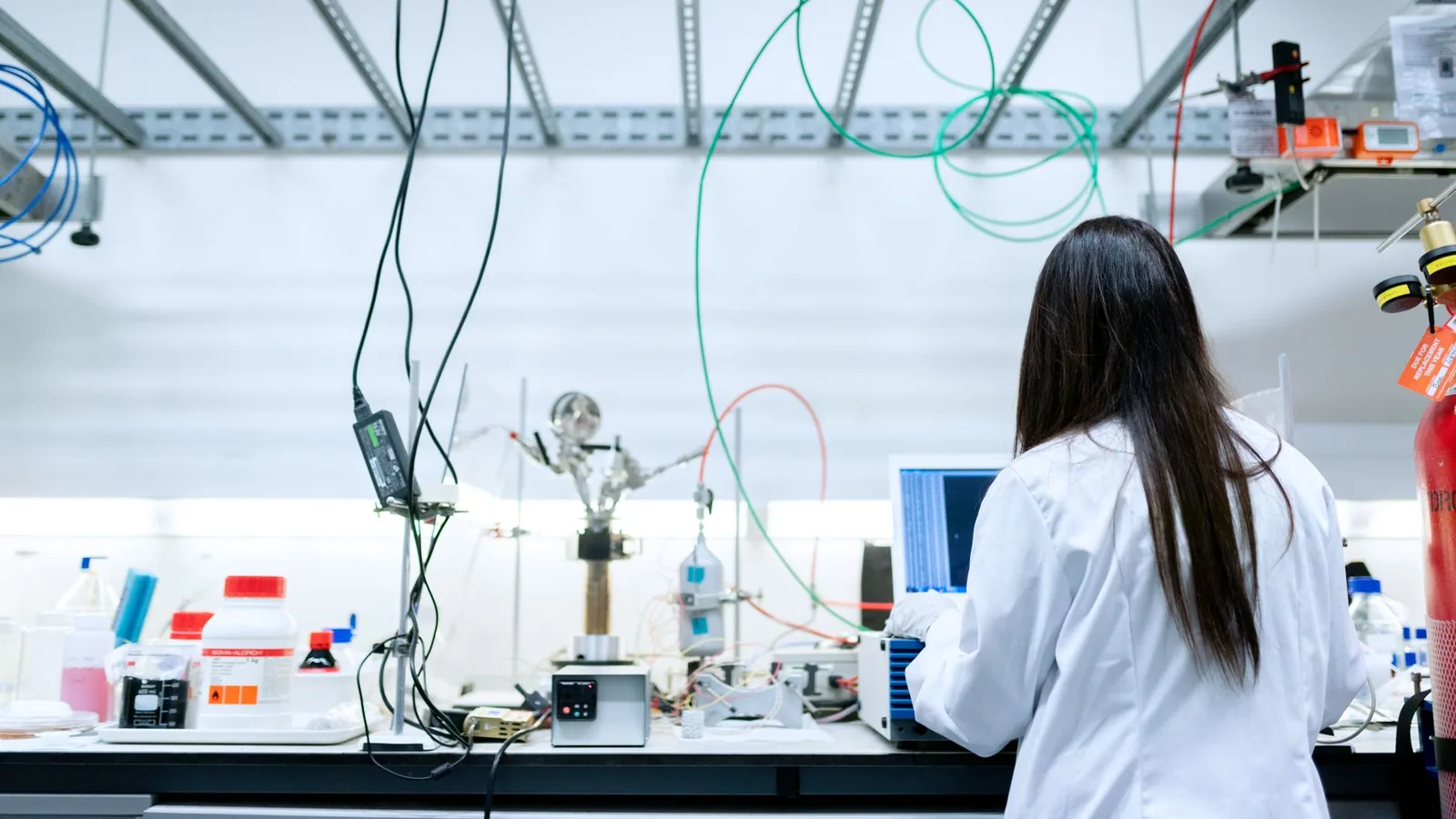 A female scientist conducting research in a contemporary laboratory full of equipment