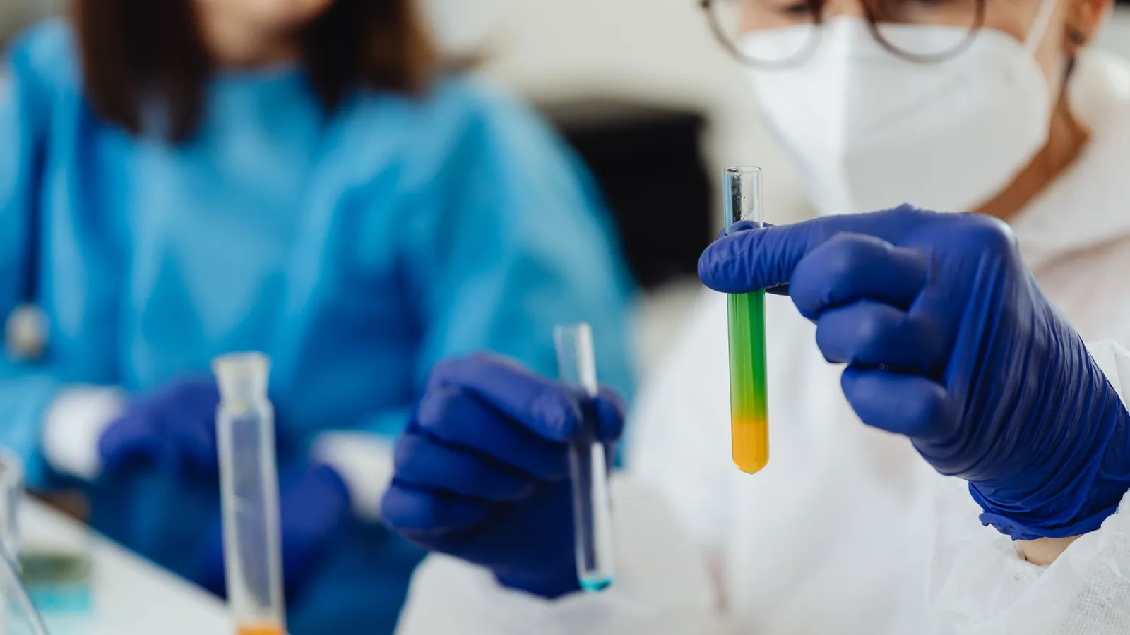 Close-up of scientists working with colorful test tubes in a laboratory setting