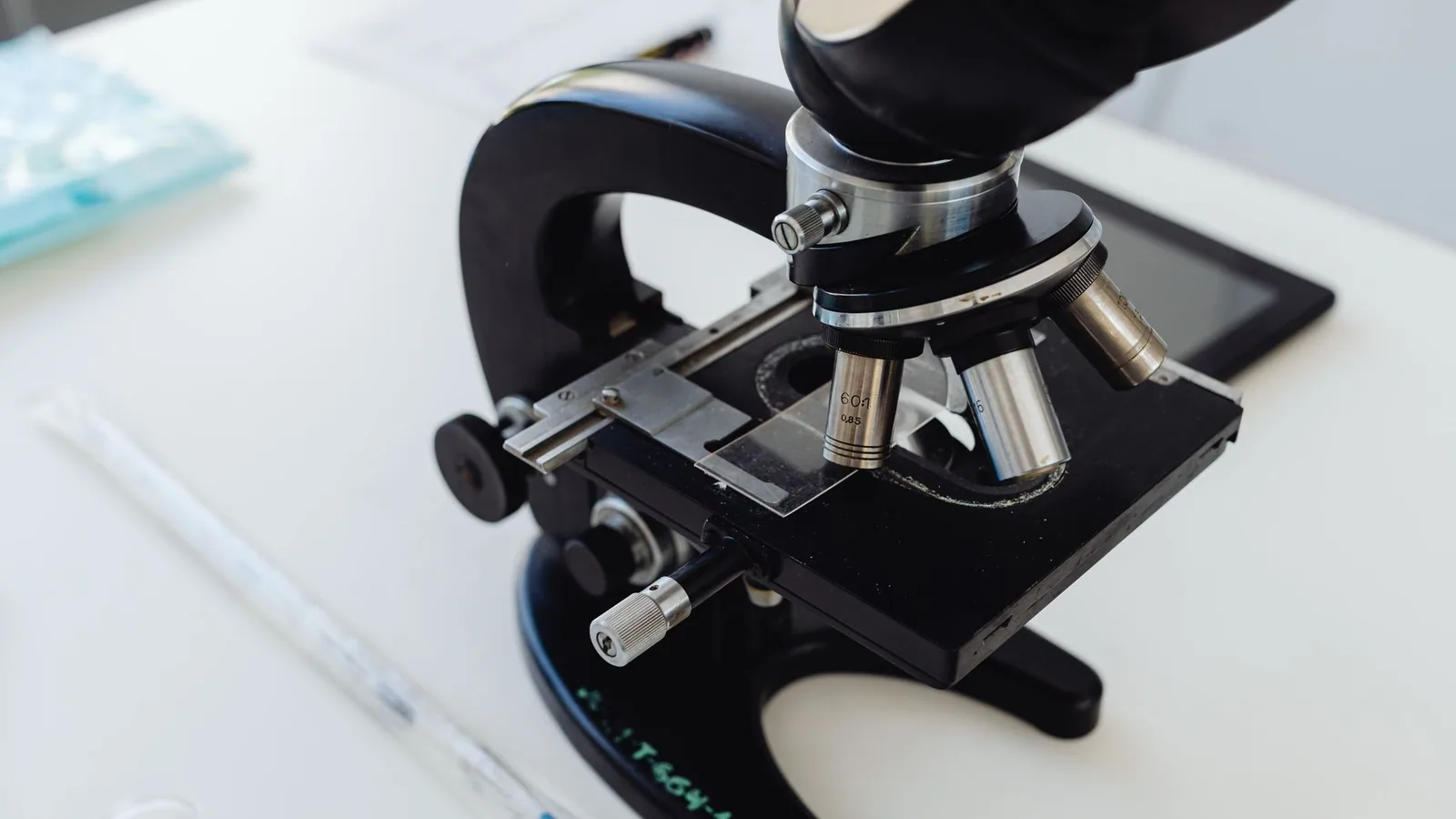 Detailed photo of a microscope on a laboratory desk, symbolizing scientific research