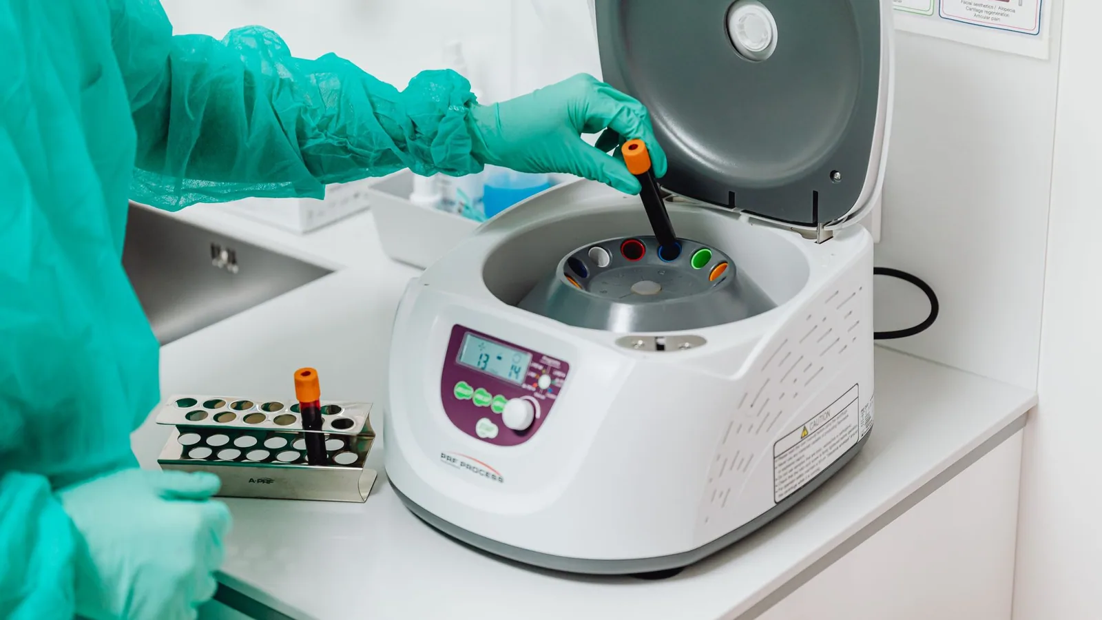 A healthcare professional operates a centrifuge machine in a laboratory, ensuring sterile medical procedures
